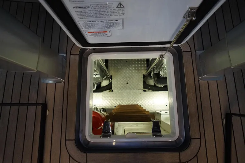 Slide: The Image of Engine room access hatch on 2016 Pershing 70 yacht, featuring wooden deck and metal stairs. - 31