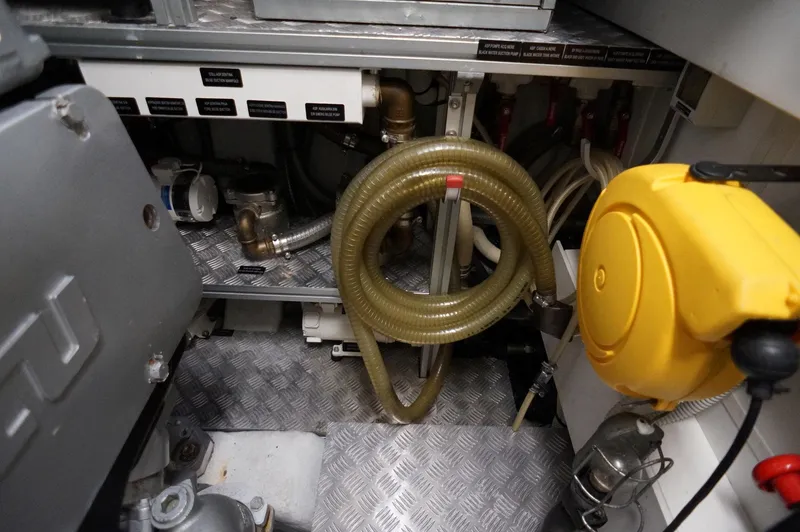 Slide: The Image of Engine room of a 2016 Pershing 70 yacht with hoses and mechanical components. - 38
