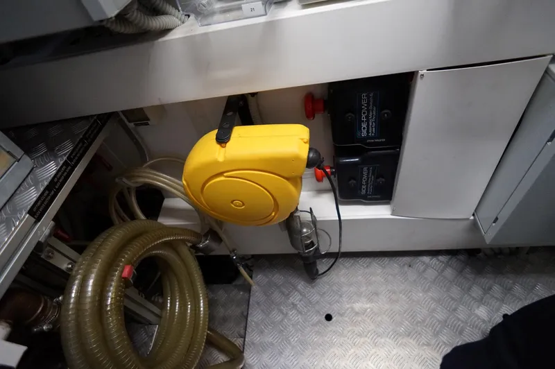 Slide: The Image of Engine room of 2016 Pershing 70 yacht with yellow hose reel and battery compartment. - 42