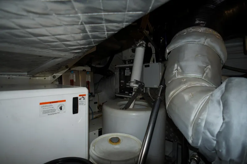 Slide: The Image of Engine room of a 2016 Pershing 70 yacht, featuring machinery and insulated pipes. - 46
