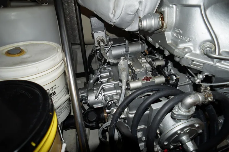 Slide: The Image of Engine compartment of a 2016 Pershing 70 yacht, showcasing mechanical components and hoses. - 48