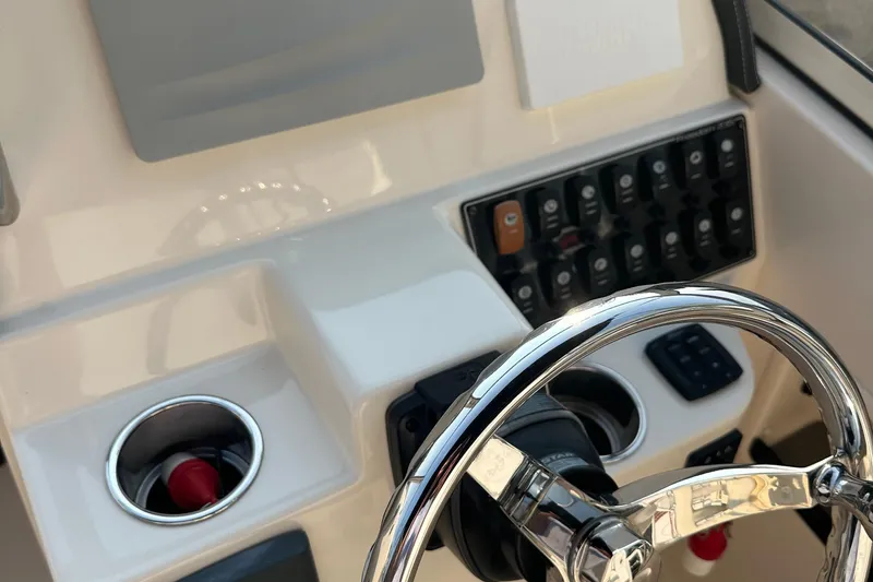 Slide: The Image of 2017 Grady White 235 boat dashboard with steering wheel and control panel. - 14