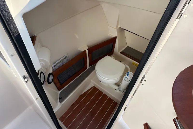 Slide: The Image of 2017 Grady White 235 boat interior with compact marine toilet and wooden flooring. - 8