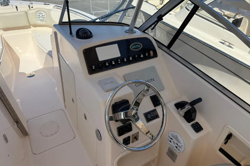 Slide: The Image of 2012 Grady-White Freedom 275 boat helm with steering wheel and controls. - 2