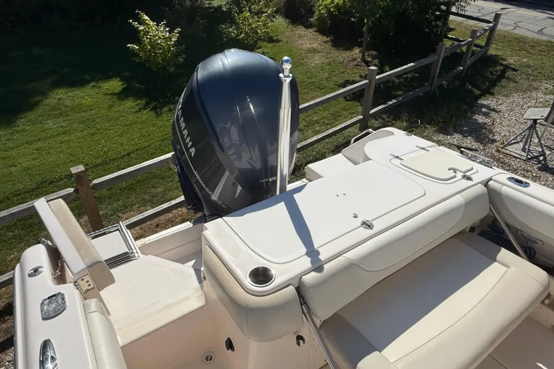 Slide: The Image of 2012 Grady-White Freedom 275 boat with Yamaha outboard motor, docked near a grassy area. - 5
