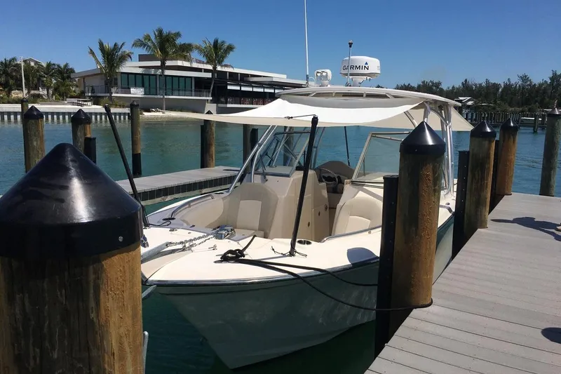 Slide: The Image of 2012 Grady-White Freedom 275 boat docked at marina with canopy and clear skies. - 6