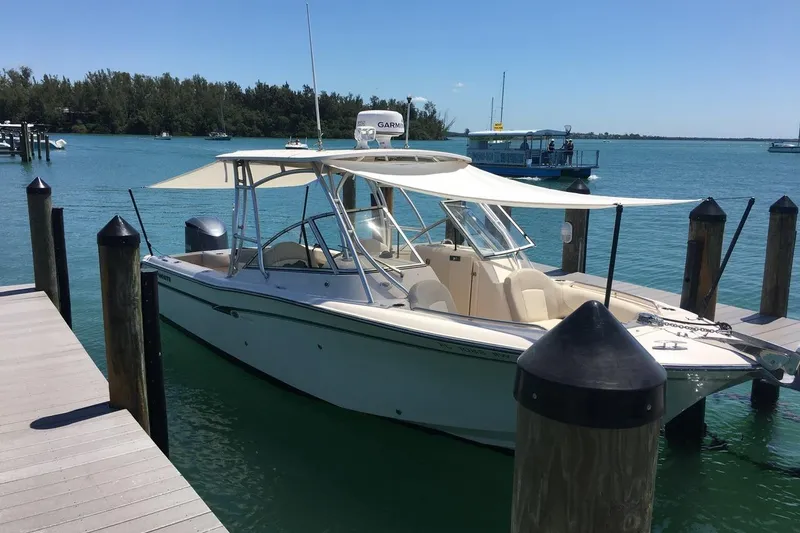 Slide: The Image of 2012 Grady-White Freedom 275 boat docked in a serene marina setting. - 8