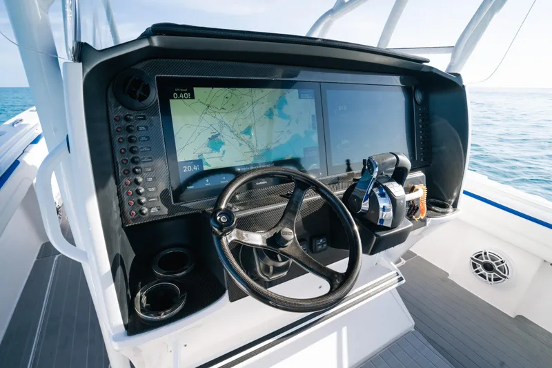 Slide: The Image of 2022 Nor-Tech 392 Super Fish boat dashboard with navigation screens and steering wheel. - 20
