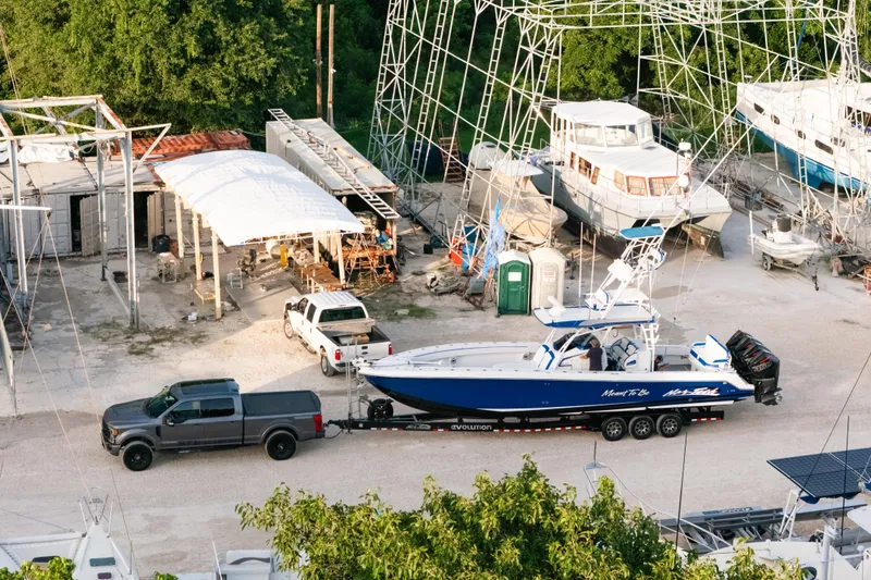 Slide: The Image of 2022 Nor-Tech 392 Super Fish boat on trailer at a marina with surrounding boats. - 52