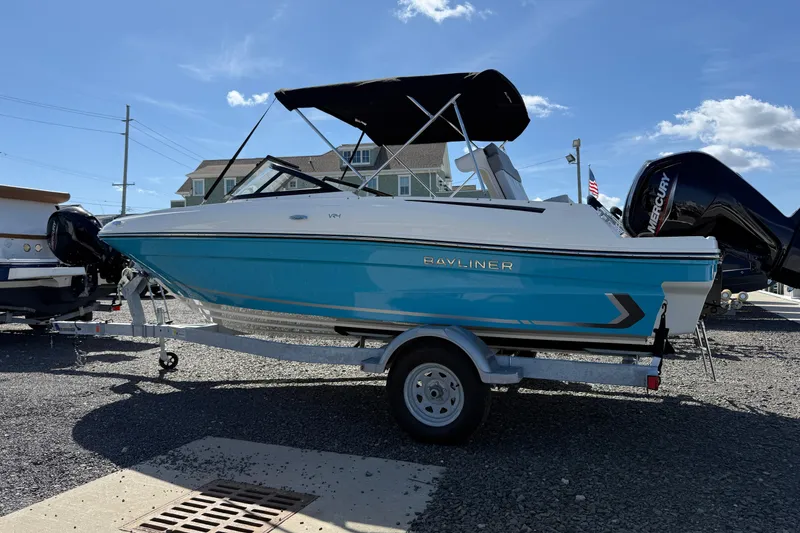The Image of 2025 Bayliner VR4 Bowrider OB boat on trailer, blue and white design, outdoor display. - 1