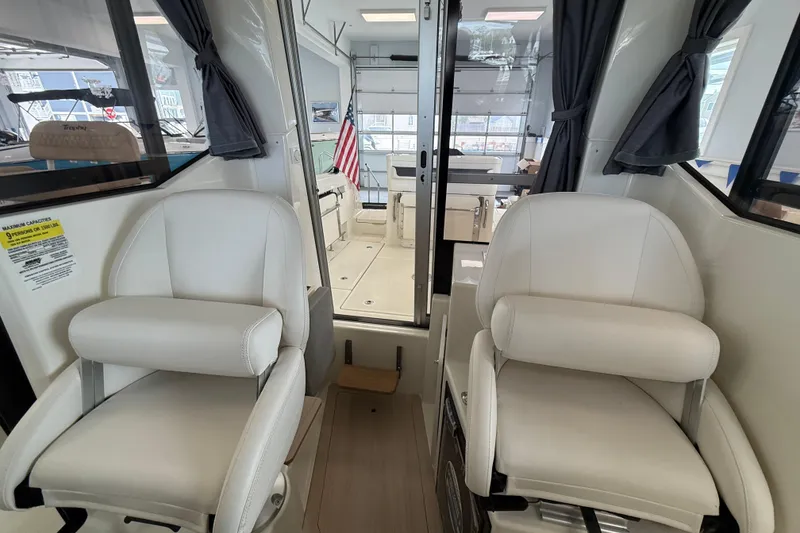 Slide: The Image of 2025 Bayliner Trophy T23 Pilothouse boat interior with seating and railing details. - 12