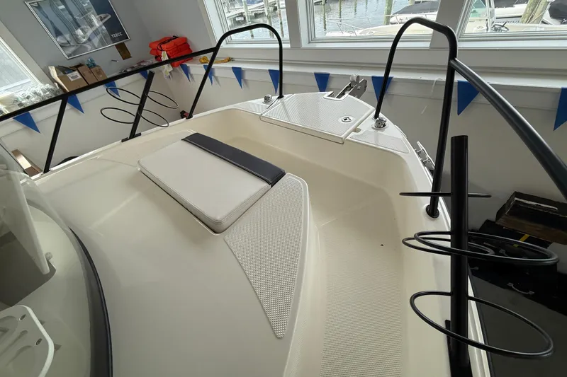 Slide: The Image of 2025 Bayliner Trophy T23 Pilothouse boat interior with seating and railing details. - 15