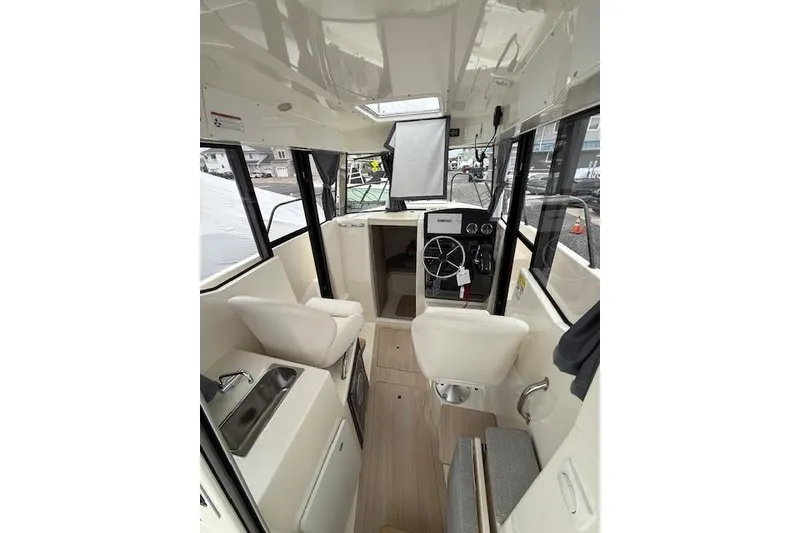 Slide: The Image of Interior of 2025 Bayliner Trophy T23 Pilothouse with steering wheel and seating. - 18