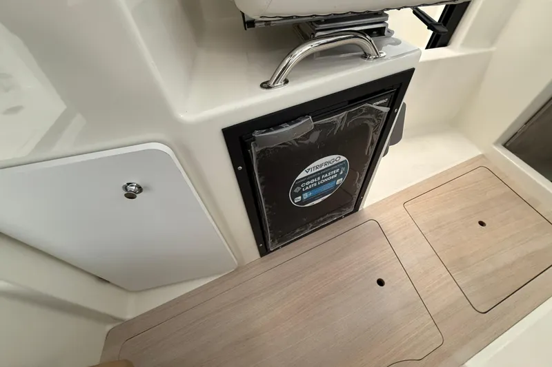 Slide: The Image of 2025 Bayliner Trophy T23 Pilothouse interior with compact sink and seating. - 7