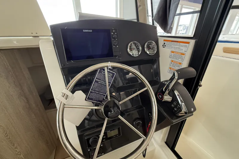 Slide: The Image of 2025 Bayliner Trophy T23 Pilothouse cabin interior with cushioned seating and storage. - 9