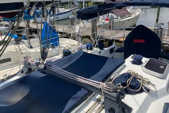 Slide: The Image of 1990 C&C 30-2 sailboat with blue covers docked at a marina. - 10