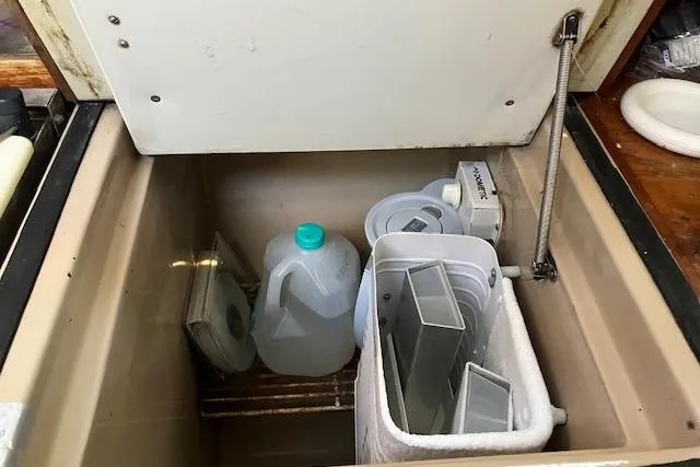 Slide: The Image of Storage compartment on a 1990 C&C 30-2 sailboat with various containers. - 19