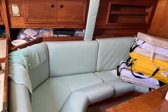Slide: The Image of 1990 C&C 30-2 sailboat interior with cushioned seating and wooden cabinetry. - 23
