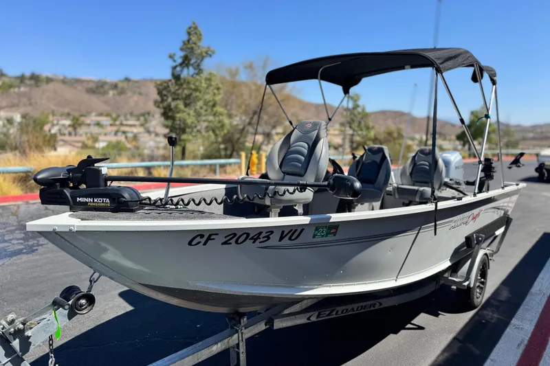 Slide: The Image of 2020 Alumacraft Escape 165 SC boat on trailer with Minn Kota motor, parked outdoors. - 3