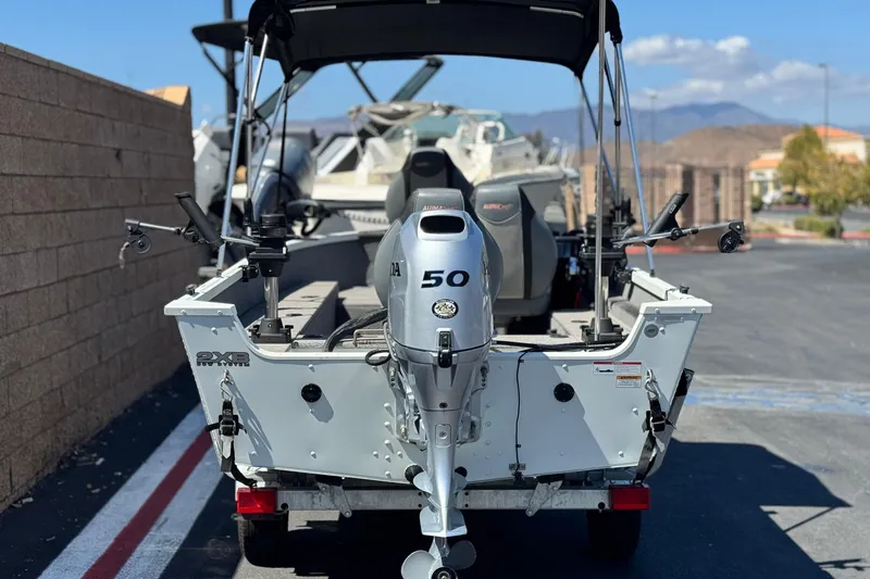 Slide: The Image of 2020 Alumacraft Escape 165 SC boat with Honda 50 outboard motor, parked outdoors. - 4