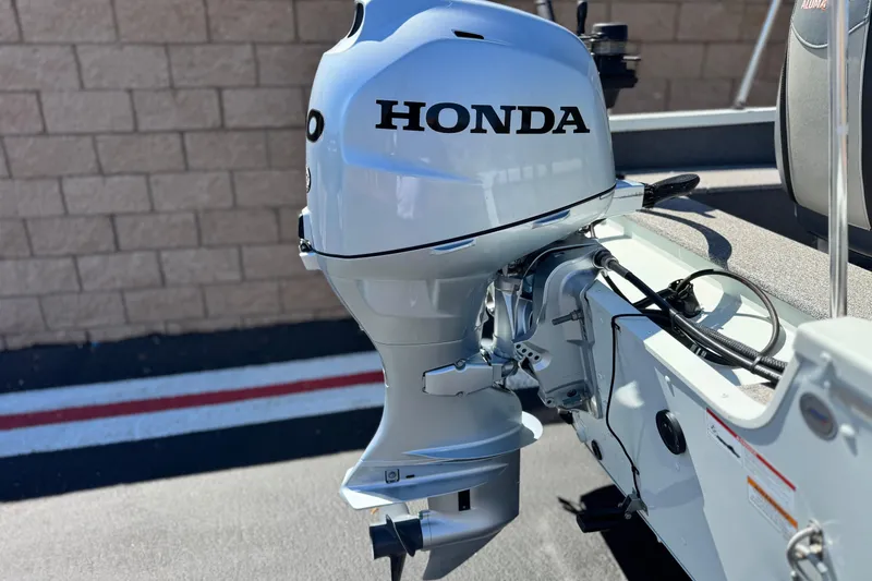 Slide: The Image of 2020 Alumacraft Escape 165 SC with Honda outboard motor, parked on pavement. - 6