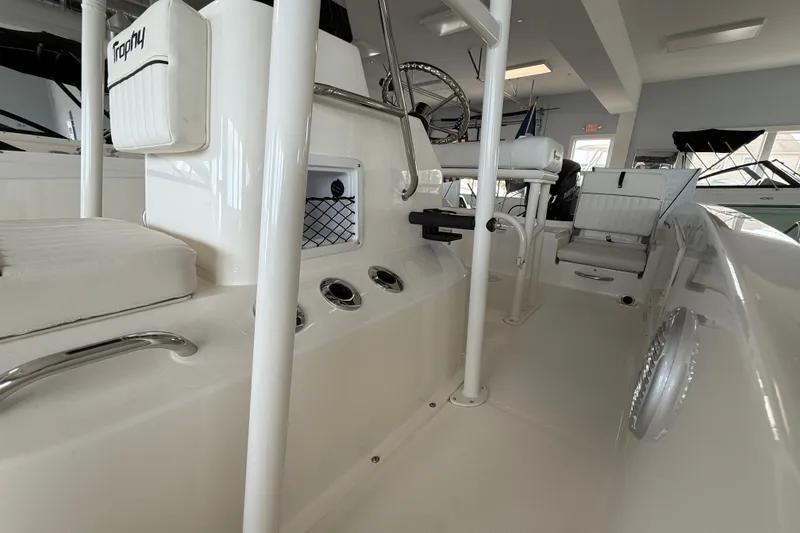 Slide: The Image of 2025 Bayliner Trophy T18 boat interior with white seating and storage compartments. - 10