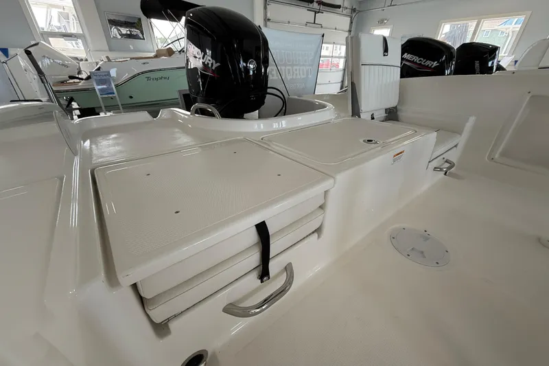 Slide: The Image of 2025 Bayliner Trophy T18 boat interior with Mercury engine in showroom. - 13