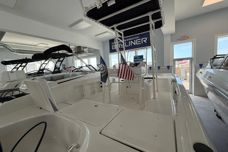 Slide: The Image of 2025 Bayliner Trophy T18 boat displayed in a showroom with American flag. - 14