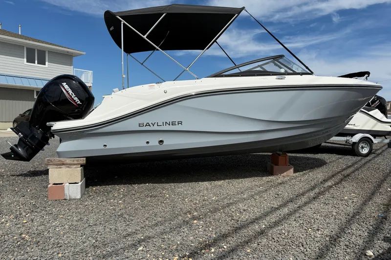 The Image of 2025 Bayliner V20 boat with Mercury engine on display, parked on gravel. - 0