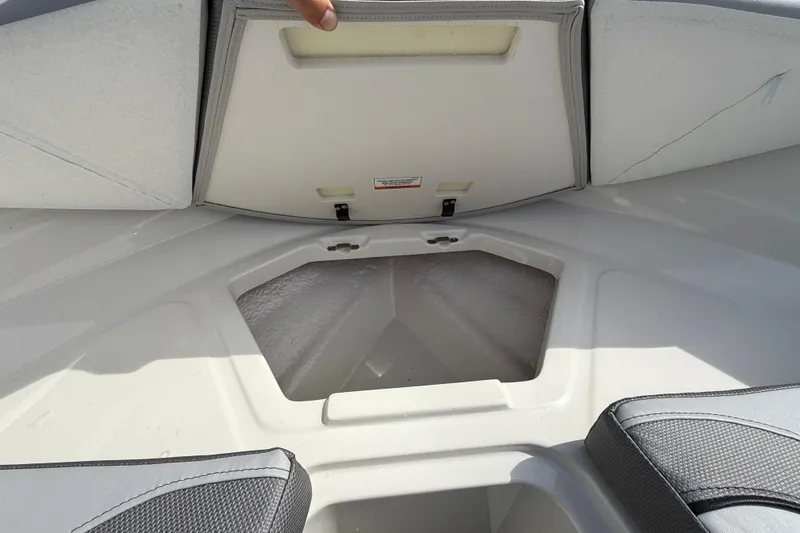Slide: The Image of 2025 Bayliner V20 boat storage compartment with open hatch and cushioned seating. - 17