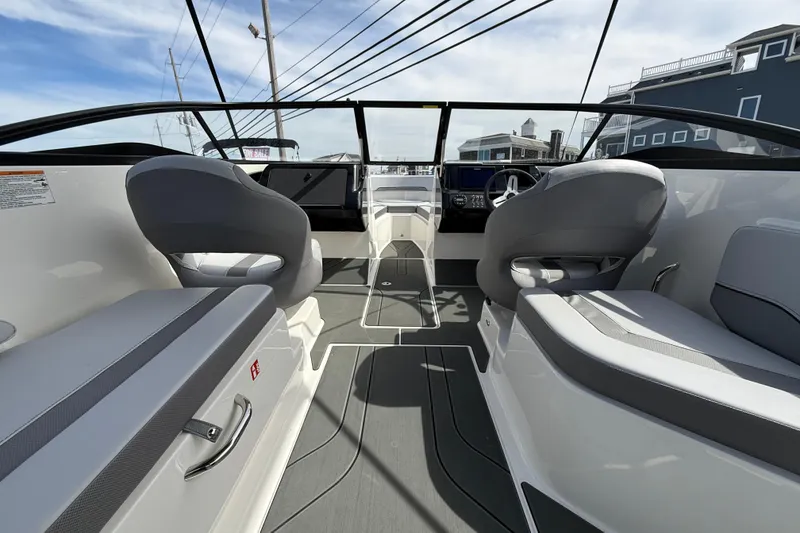 Slide: The Image of 2025 Bayliner V20 boat interior with modern seating and dashboard, under a clear sky. - 4