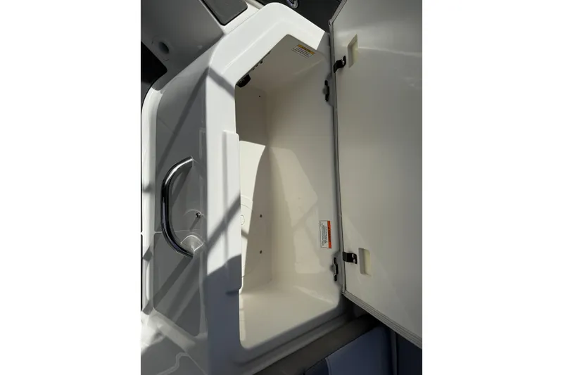 Slide: The Image of Open storage compartment on 2025 Bayliner V20 boat, featuring sleek design and chrome handle. - 7