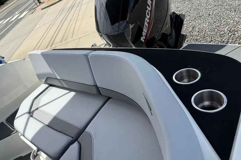 Slide: The Image of 2025 Bayliner V20 boat interior with cushioned seating and dual cup holders. - 8