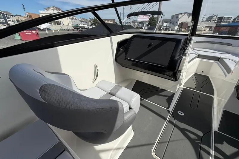 Slide: The Image of 2025 Bayliner V20 boat interior with modern seating and dashboard, docked in a marina. - 9