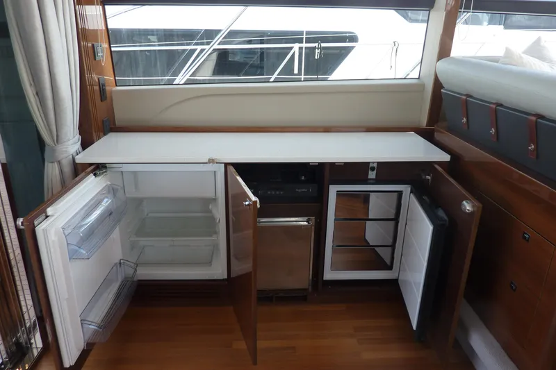 Slide: The Image of Interior view of a 2017 Princess 52 yacht kitchen with open cabinets and appliances. - 19