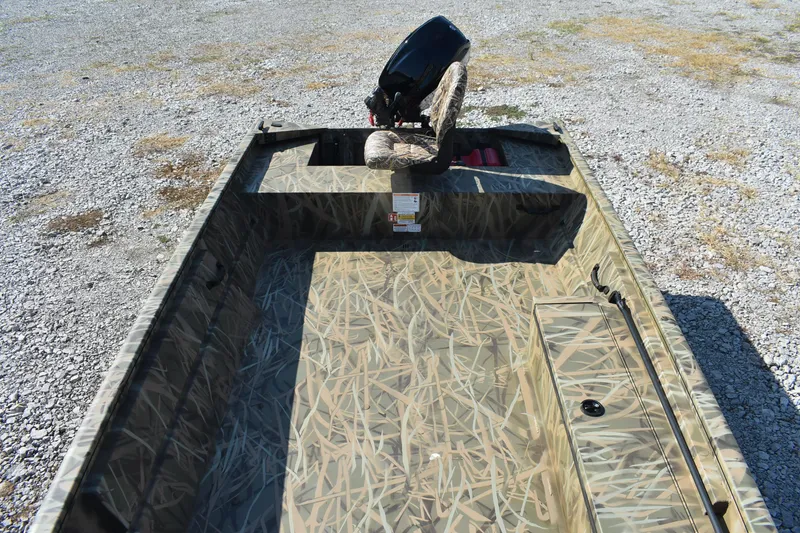 Slide: The Image of 2026 Lowe Roughneck 1860 boat with camouflage design on gravel surface. - 11