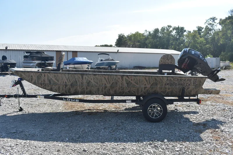 Slide: The Image of 2026 Lowe Roughneck 1860 boat on trailer, camo design, parked outdoors. - 4