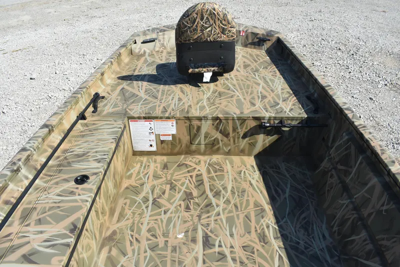 Slide: The Image of 2026 Lowe Roughneck 1860 boat with camouflage interior design on gravel surface. - 7