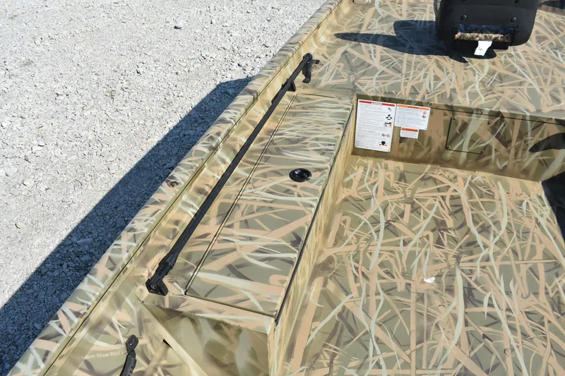 Slide: The Image of 2026 Lowe Roughneck 1860 boat with camouflage design on gravel surface. - 8