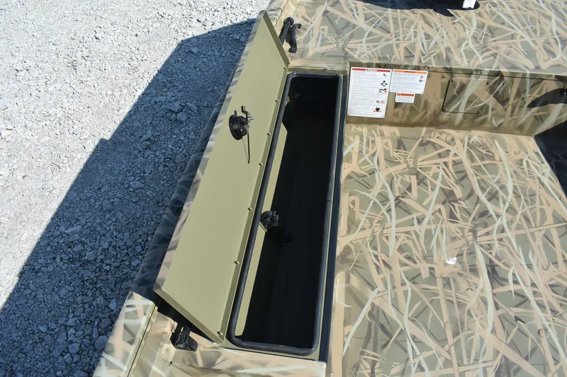 Slide: The Image of Open storage compartment on 2026 Lowe Roughneck 1860 boat with camouflage design. - 9