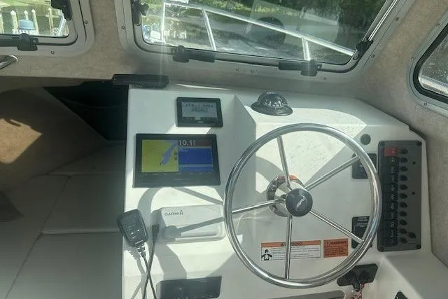 Slide: The Image of 2022 Parker 2320 SL Sport Cabin helm with steering wheel and navigation equipment. - 3