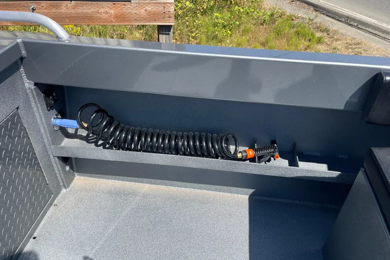 Slide: The Image of Interior of 2025 Excel Buoy 10 boat with coiled hose and storage compartment. - 22