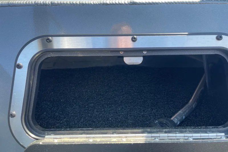 Slide: The Image of 2025 Excel Buoy 10 boat storage compartment with metal frame and carpeted interior. - 33