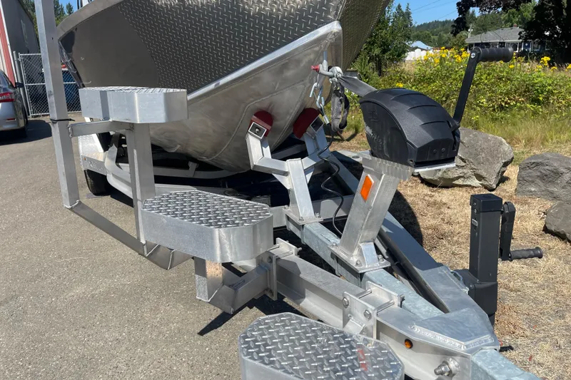 Slide: The Image of 2025 Excel Buoy 10 boat trailer with aluminum steps and hitch, parked outdoors. - 38
