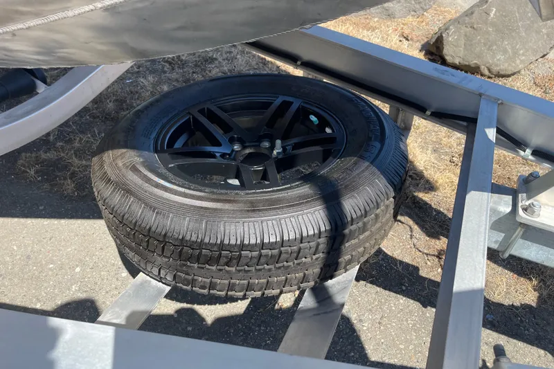 Slide: The Image of Spare tire on Excel Buoy 10 trailer, 2025 model, parked on asphalt. - 39