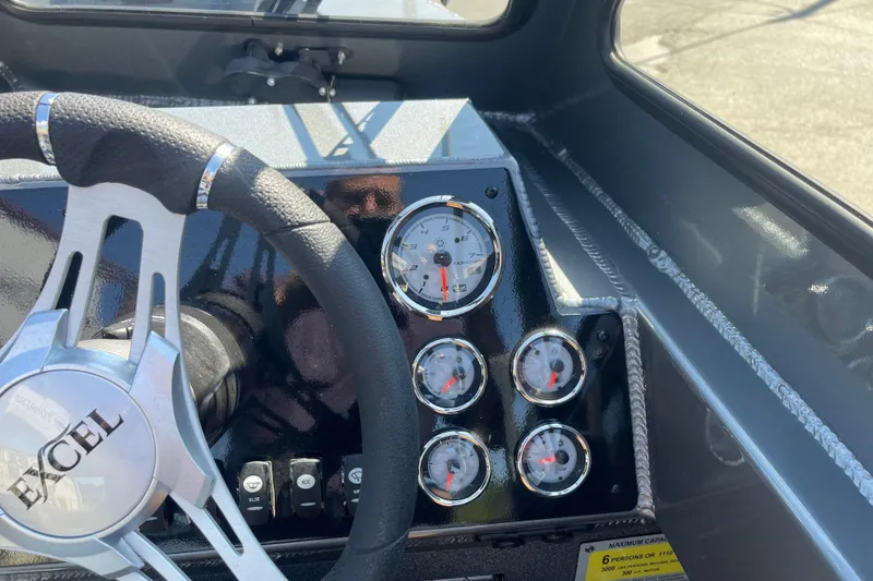 Slide: The Image of Steering wheel and dashboard of 2025 Excel Buoy 10 boat with gauges. - 40