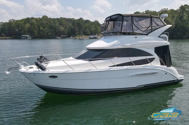 Slide: The Image of 2007 Meridian 341 Sedan yacht on a serene lake with lush green shoreline. - 1