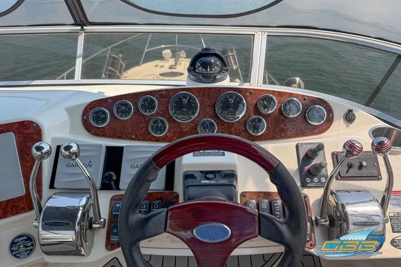 Slide: The Image of 2007 Meridian 341 Sedan helm with gauges, steering wheel, and throttle controls on a sunny day. - 18