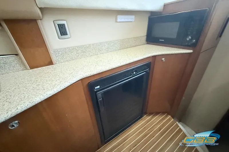 Slide: The Image of 2007 Meridian 341 Sedan interior with kitchenette, featuring microwave and compact fridge. - 24