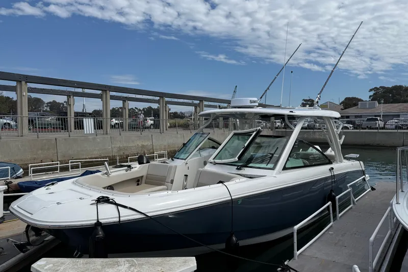 The Image of 2023 Boston Whaler 320 Vantage boat docked at marina under partly cloudy sky. - 0